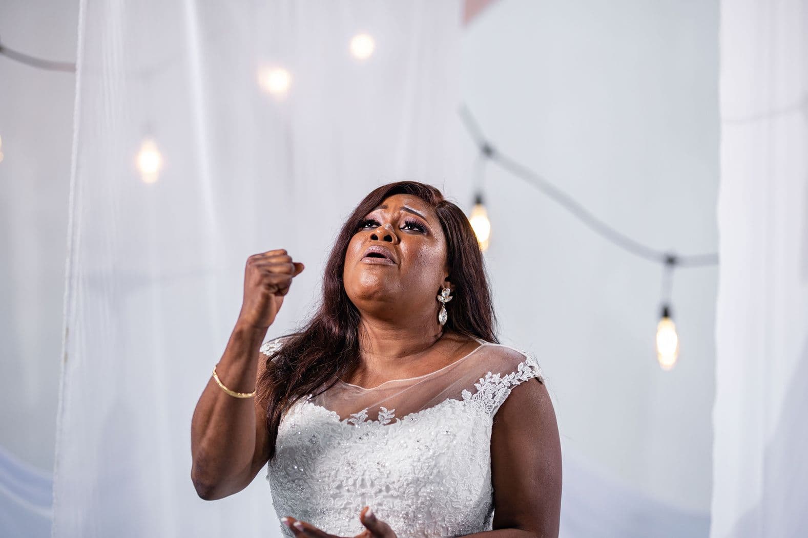 A close portrait of the singer in a lace bridal gown