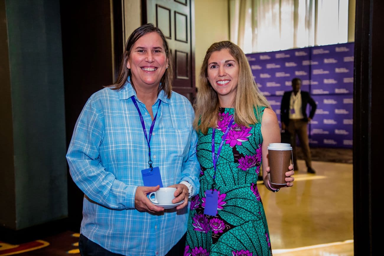 Two women smiling with cups of coffee