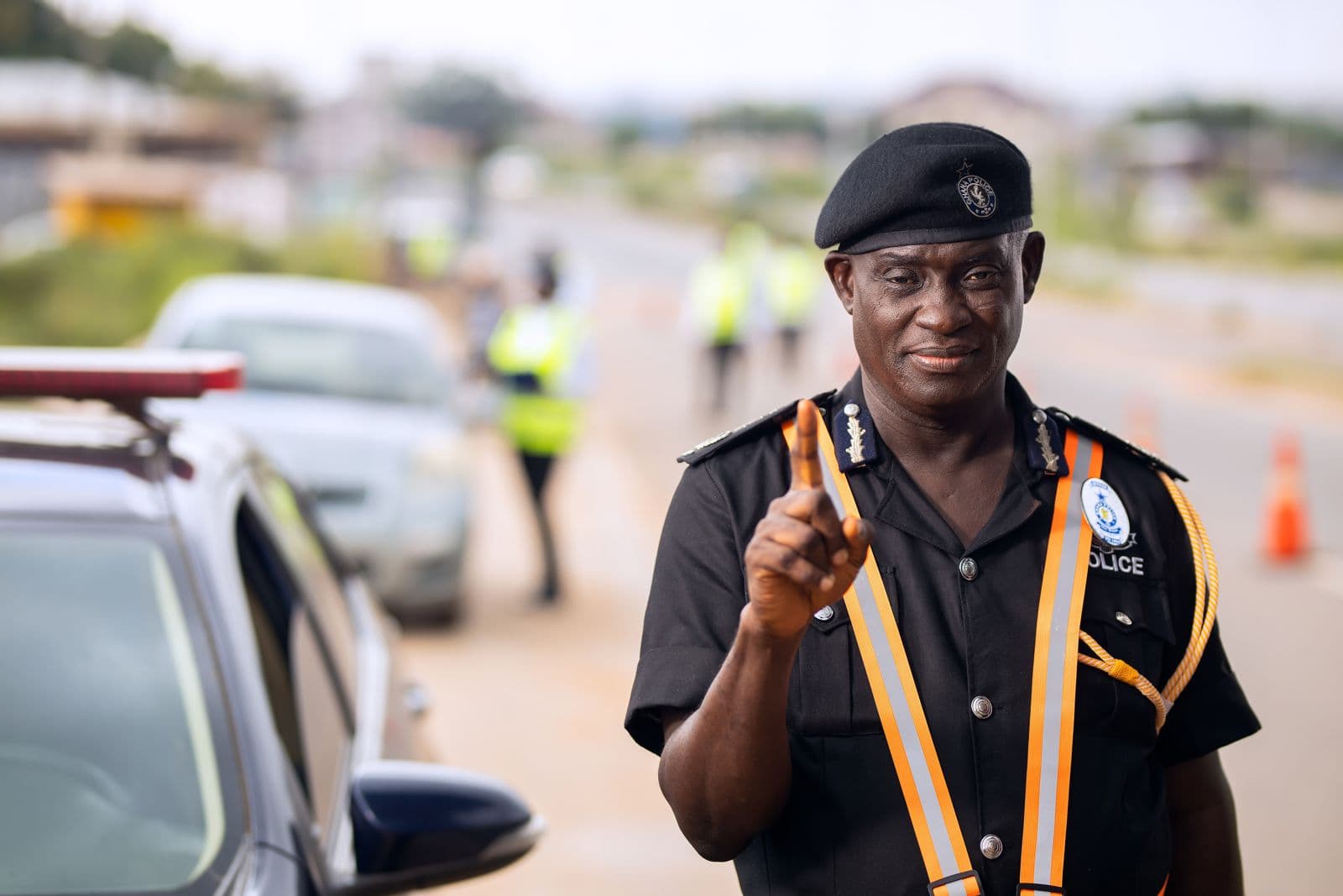 A traffic officer in uniform raising a finger on a roadside