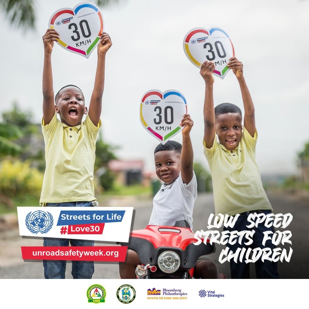 Children holding 30 km/h heart-shaped signs
