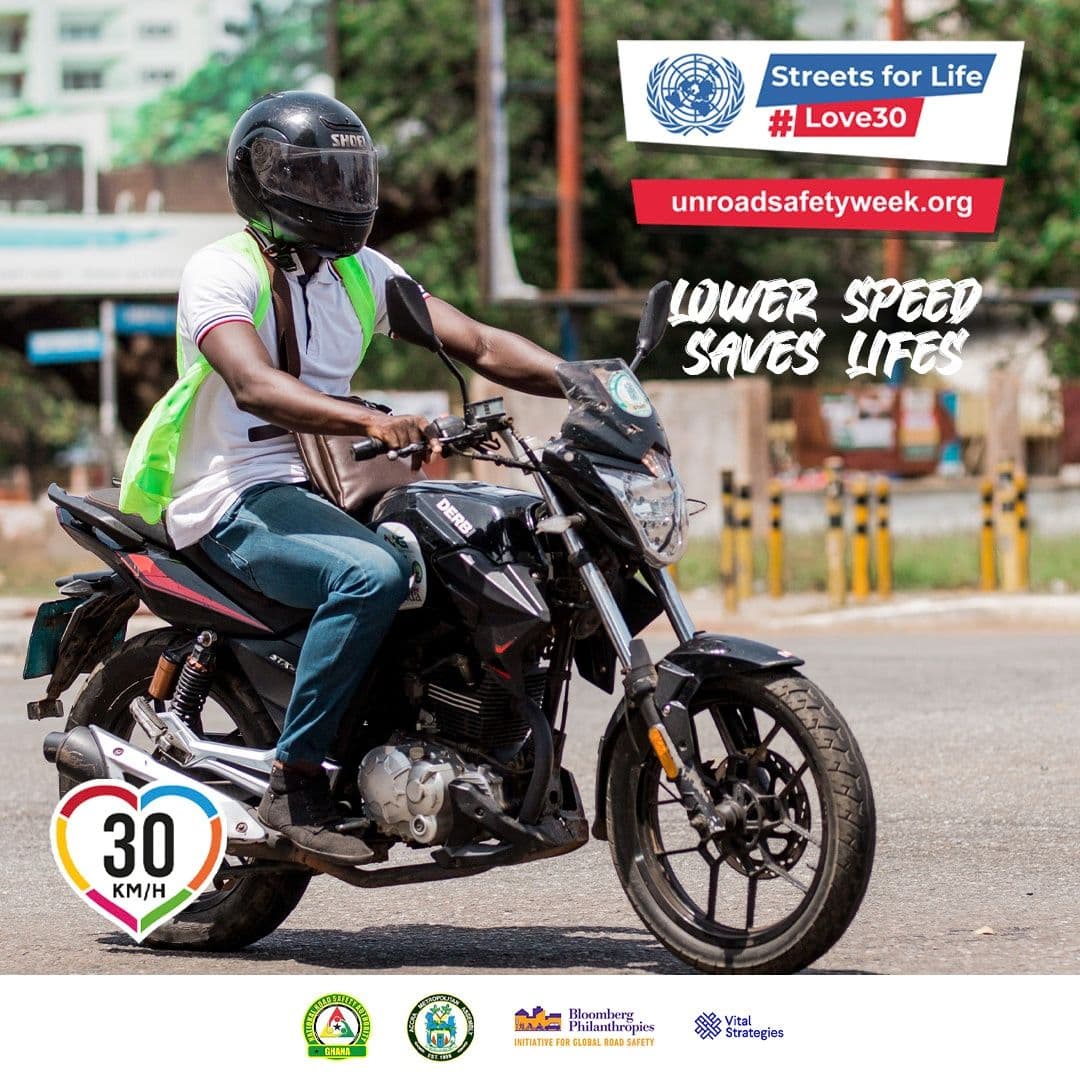 A motorcycle rider on the road, with a lower speed message