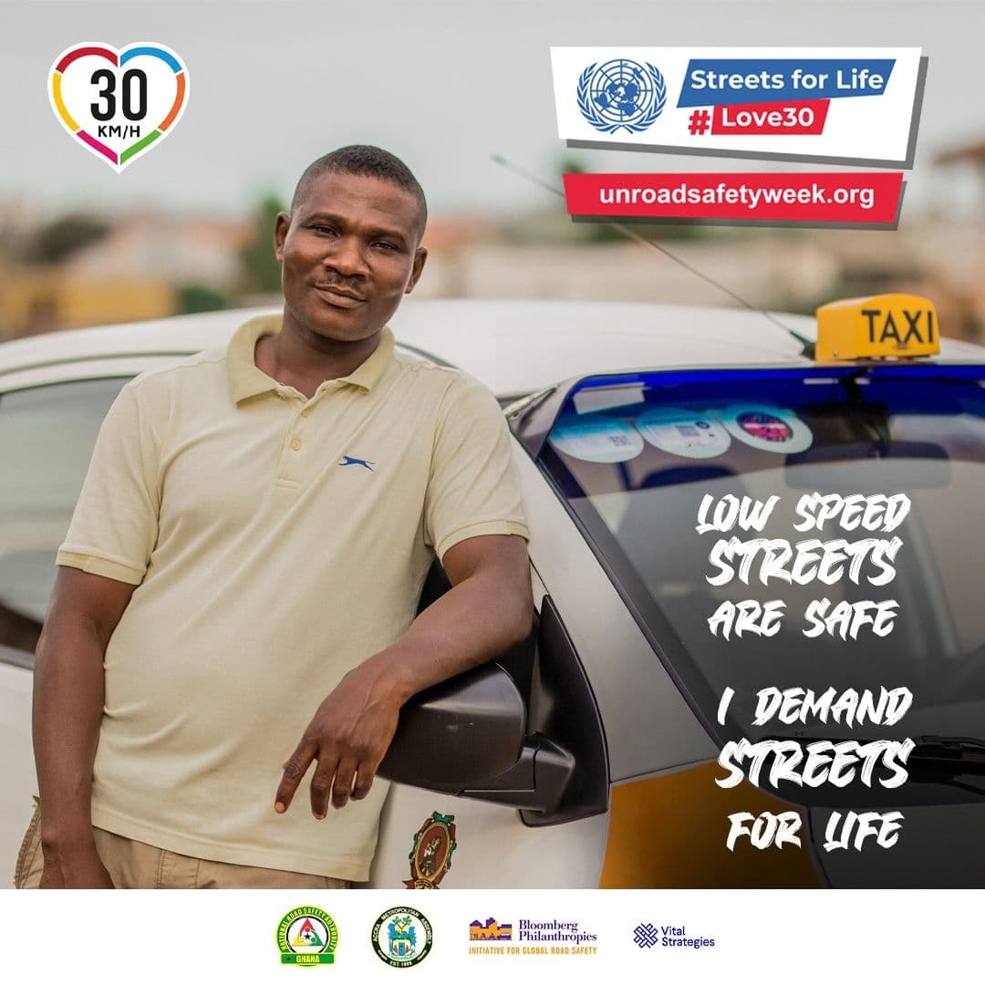 A man leaning on a taxi, with a street safety message