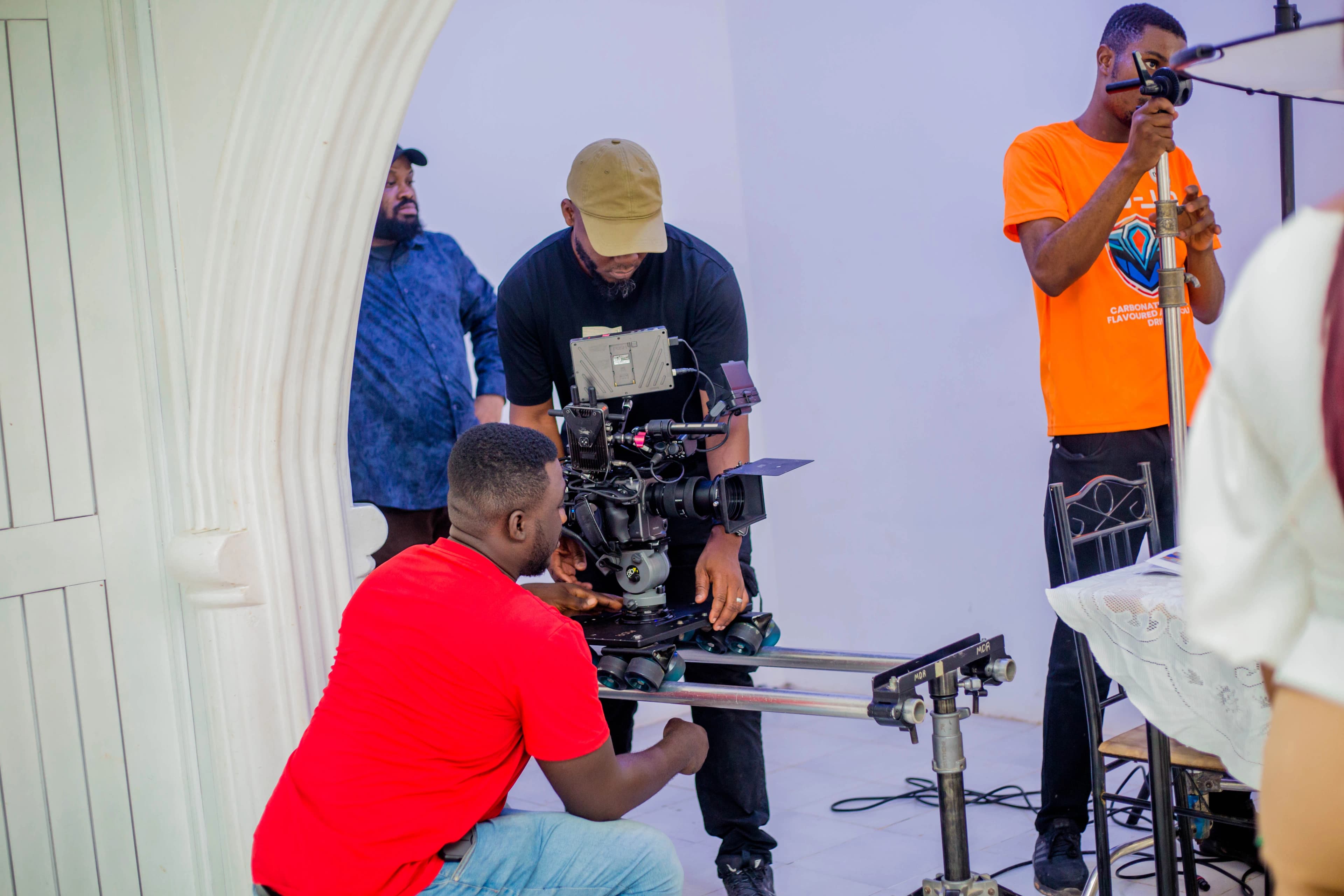 A crew setting up a camera on a dolly inside a home
